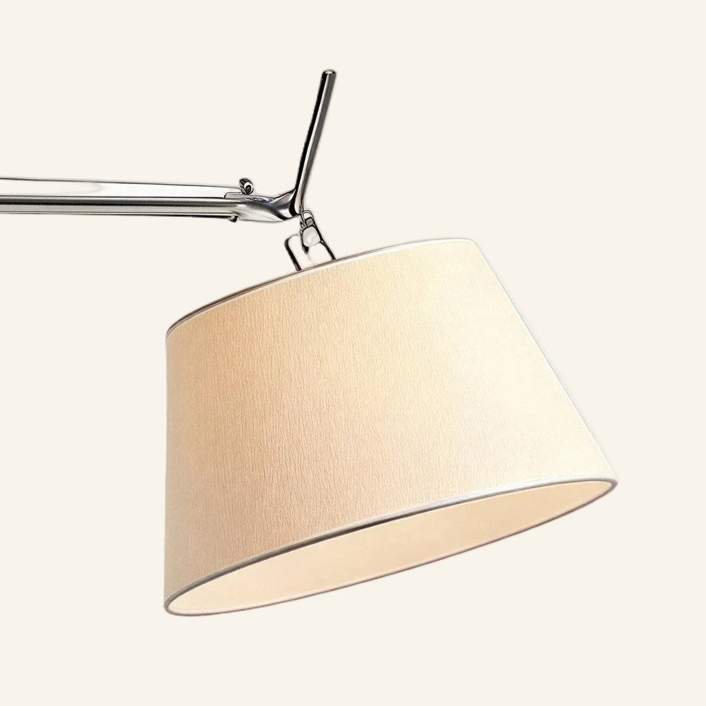 Close-up of the tapered ivory fabric shade and articulated polished aluminum joint showing pivot hardware and woven textile texture.