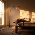 Japandi living room at golden hour with the arc lamp curving over a linen sofa, wood coffee table, and round jute rug.