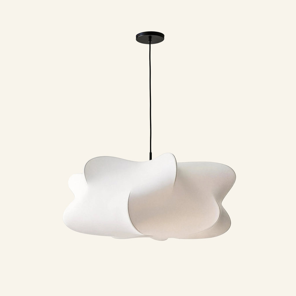 Cloud-shaped white faux silk pendant lamp with irregular sculptural lobes, suspended from a black canopy on cream studio backdrop.