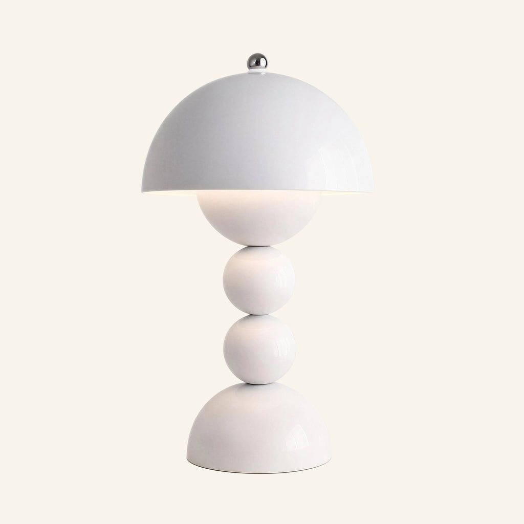 Glossy white mushroom dome table lamp with chrome finial, stacked sphere stem and half-dome base, lit on a cream backdrop
