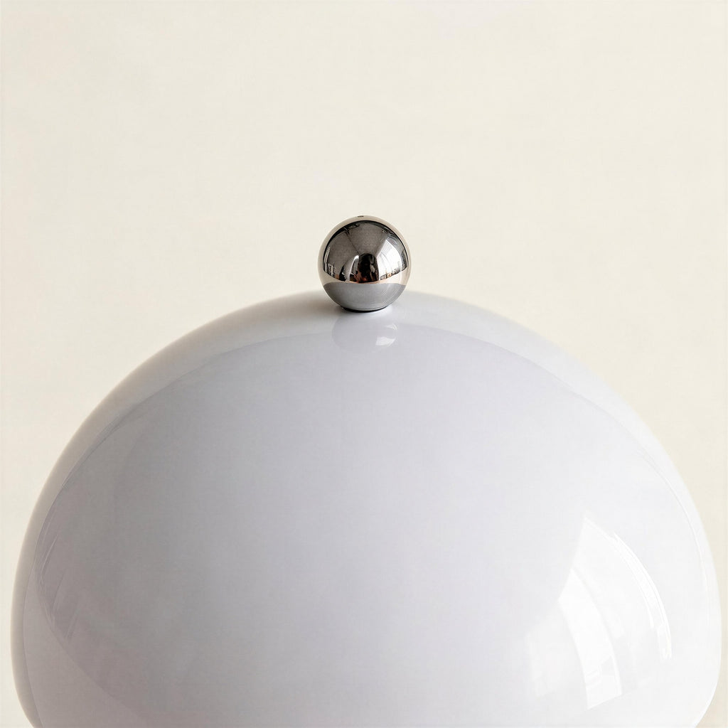 Close-up of the glossy white ABS dome shade topped by a polished chrome ball finial, showing seamless lacquered finish