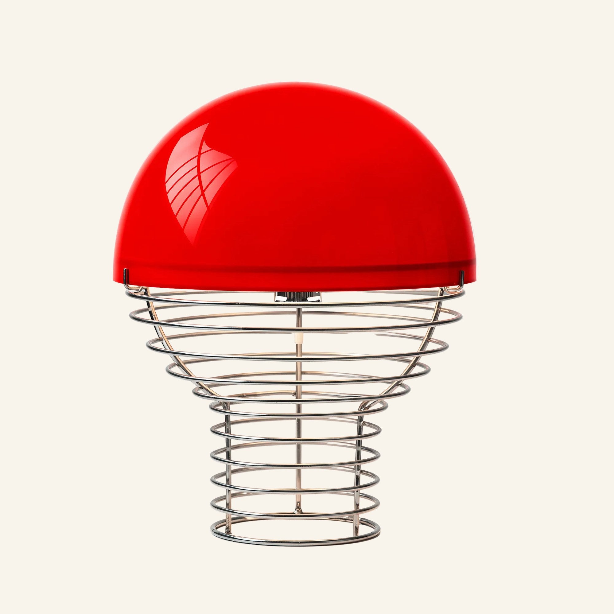 Vivid red glass half-sphere shade paired with a stacked chrome wire cage base, bauhaus table lamp colour variant on cream backdrop.
