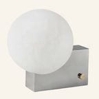 Frosted opal glass globe shade on a polished chrome rectangular block base with side-mounted brass rotary dimmer knob.