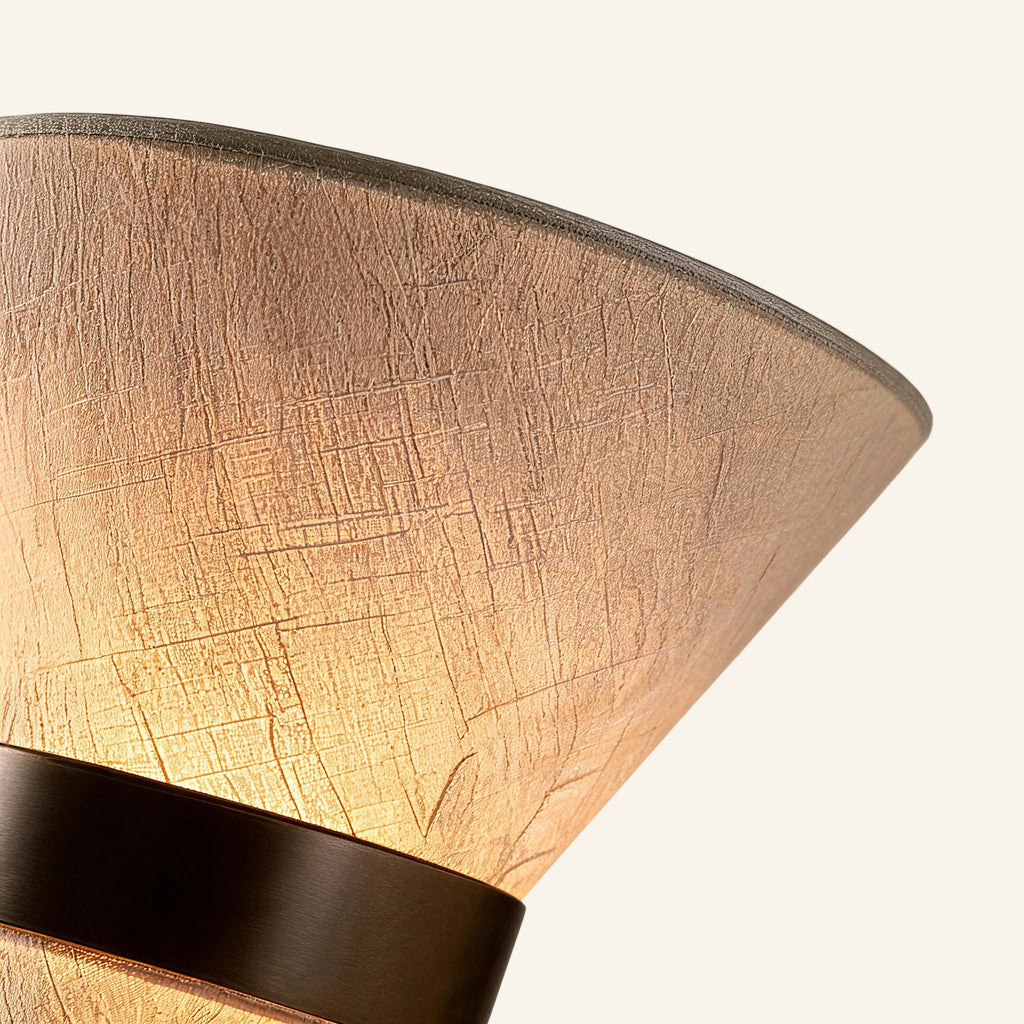 Close-up of crosshatched linen shade texture meeting the bronze iron cinch band, showing weave detail and warm tonal shift.