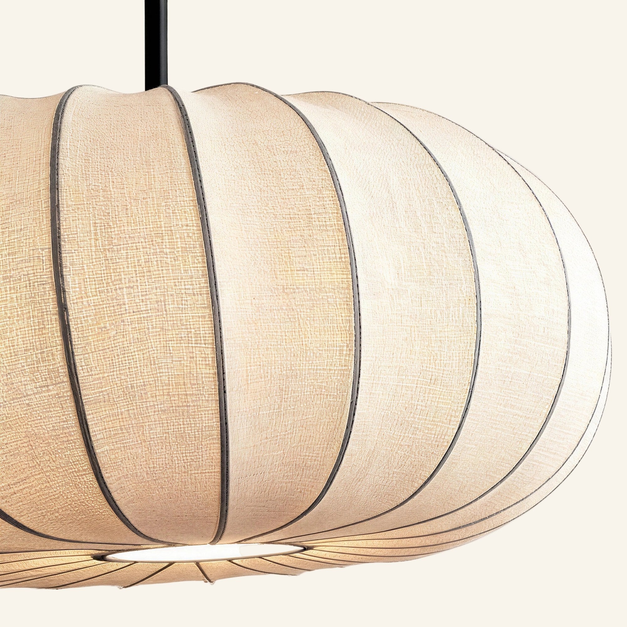 Close-up of the ribbed linen shade showing woven texture, vertical pleats, and subtle seams along the rounded pumpkin form of the pendant lamp