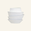 Stacked matt-white iron shells form a tiered petal sconce on cream backdrop, sculptural wall light with overlapping curved layers