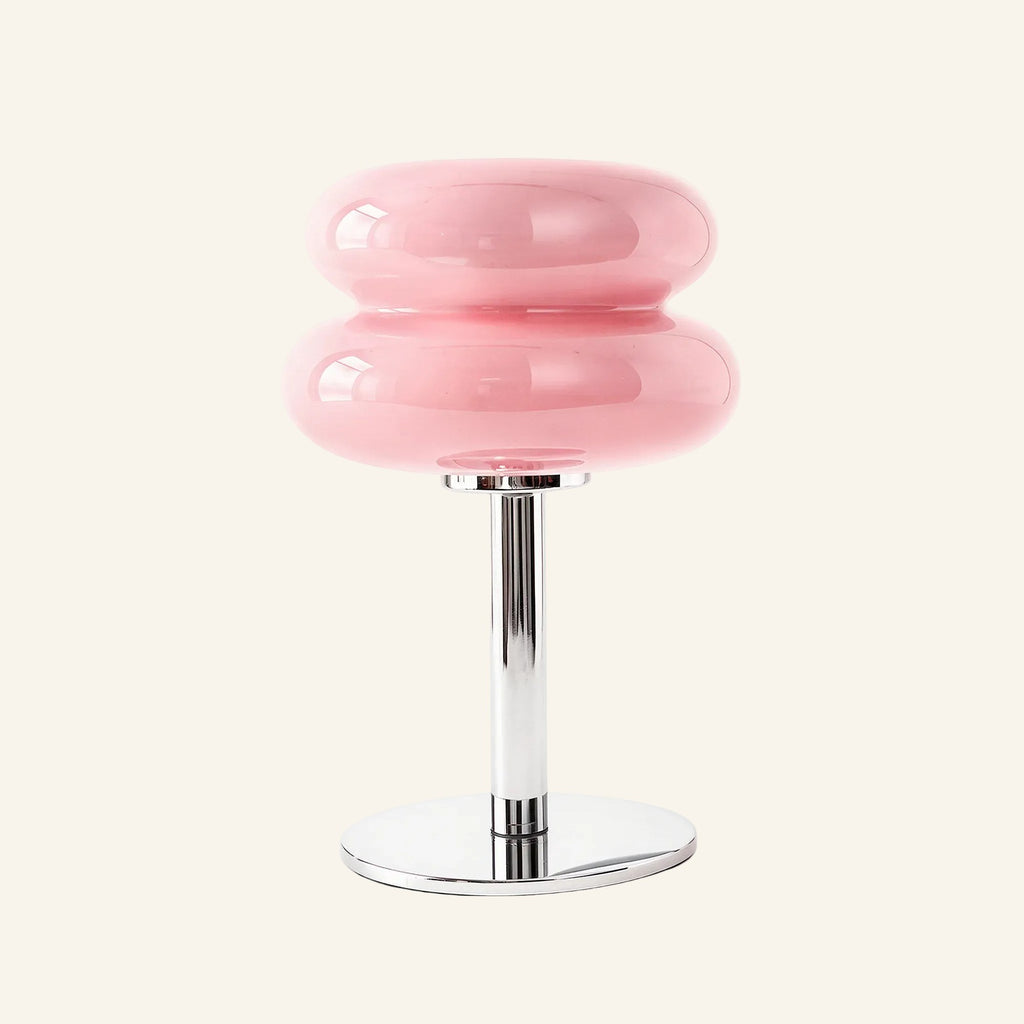 Soft pink two-tier glossy glass shade above slim chrome column and disc base, pastel mood table lamp for bedroom styling