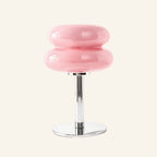 Soft pink two-tier glossy glass shade above slim chrome column and disc base, pastel mood table lamp for bedroom styling