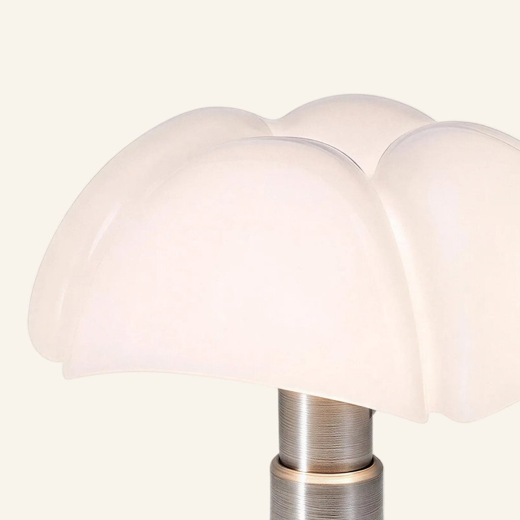 Close-up of scalloped opal acrylic dome shade showing translucent petals meeting brushed steel cylindrical stem on vintage table lamp