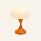 Side view of the rechargeable bedside lamp with bright orange lacquered tulip base supporting a softly lit opal mushroom shade