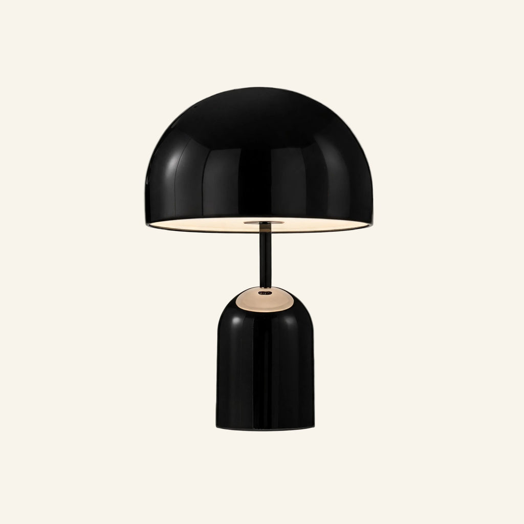 Black gloss version of the dome table lamp on cream background, mirrored shade hovering over a rounded cylindrical metal base