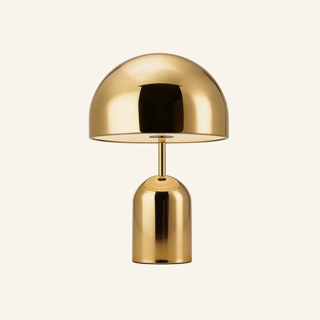 Brass-finish variant of the dome table lamp on cream background, golden polished shade above a tall cylindrical base with touch button