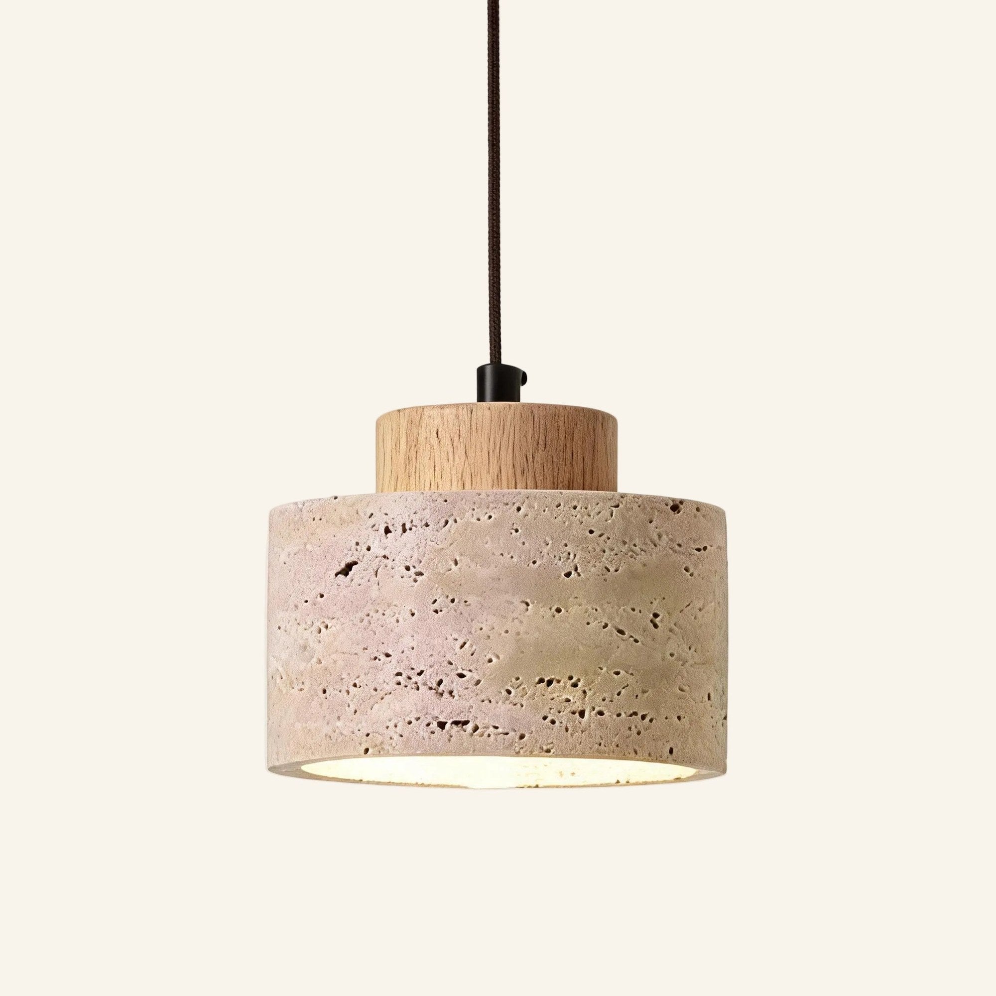 Travertine pendant lamp variant with pale beech wood cap, suspended on a dark braided cord on cream background.