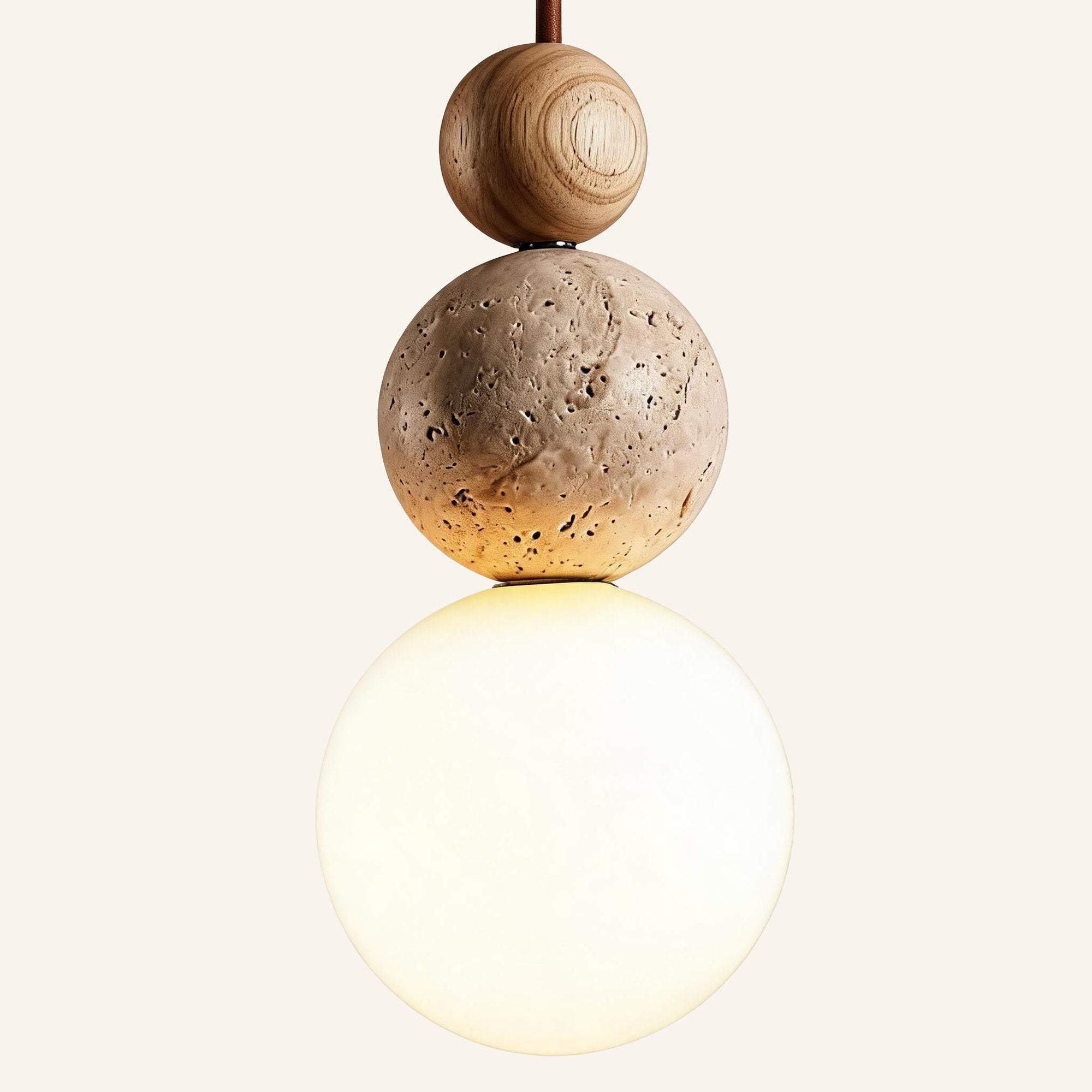 Side view of pendant light showing grained wood bead, beige travertine orb and softly lit opal glass globe stacked vertically.