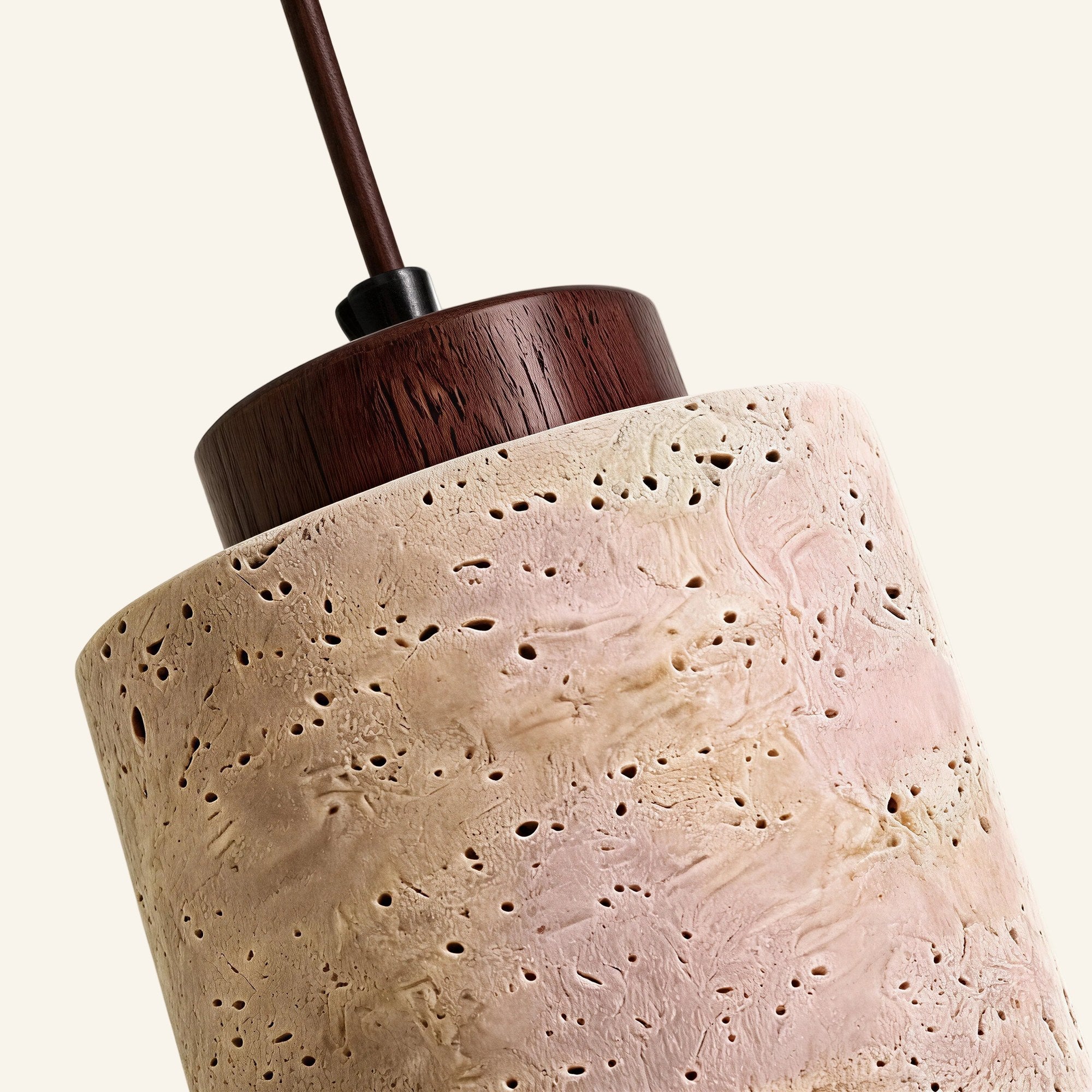 Close-up of pitted travertine shade meeting a dark walnut ring, showing porous stone texture and visible wood grain.