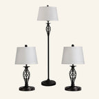 Three-piece black metal lamp set with a tall floor lamp flanked by two matching table lamps, all with white drum shades.